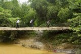 Warga melintasi jembatan gantung di Cilamaya Wetan, Karawang, Jawa Barat, Jumat (7/2/2020). Jembatan gantung yang menjadi alternatif penyeberangan antara Kabupaten Karawang dan Kabupatan Subang tersebut dalam keadaan rusak sehingga dapat membahayakan warga yang melintas. ANTARA JABAR/M Ibnu Chazar/agr