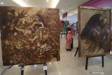 Pengunjung mengamati lukisan pada pameran lukisan bertajuk 'Obor' di Kota Kediri, Jawa Timur, Kamis (6/2/2020). Pameran yang menampilkan 70 lukisan hasil karya 47 perupa dari Kediri, Tulungagung, Nganjuk, Blitar, dan Trenggalek tersebut guna mengapresiasi perupa-perupa berbakat dari daerah. Antara Jatim/Prasetia Fauzani/zk