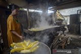 Pekerja mengangkat singkong yang telah direbus saat memproduksi peuyeum di Cipatat, Kabupaten Bandung Barat, Jawa Barat, Jumat (7/2/2020). Pekerja menyatakan, pada musim hujan produksi peuyeum menurun hingga 60 persen atau hanya memproduksi dua kuintal peuyeum dibandingkan dengan musim kemarau yang dapat memproduksi hingga lima kuintal perhari yang diakibatkan minimnya bahan baku. ANTARA JABAR/Raisan Al Farisi/agr