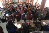 Petugas melayani warga yang mengantre untuk mendapatkan bahan pangan gratis dalam rangka Hari Pers Nasional di gedung PWI Kalsel, Banjarmasin, Kalimantan Selatan, Minggu (9/2/2020). PWI bekerja sama dengan Perum Bulog menggelar bakti sosial yakni dengan membagikan 500 bahan pangan gratis kepada warga yang kurang mampu dan pensiunan wartawan di Kalimantan Selatan. Foto Antaranews Kalsel/Bayu Pratama S.