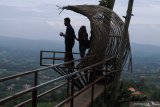 Pengunjung menikmati  panorama Wisata Puncak Ratu di Desa Tebbul, Pamekasan, Jawa Timur, Minggu (9/2/2020). Destinasi wisata di daerah ketinggian itu menyajikan keelokan lenskap dan kesegaran udara, sehingga menjadi alternatif bagi pengunjung guna menghabiskan libur akhir pekan. Antara Jatim/Saiful Bahri/zk