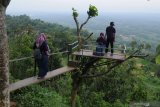 Pengunjung menikmati  panorama Wisata Puncak Ratu di Desa Tebbul, Pamekasan, Jawa Timur, Minggu (9/2/2020). Destinasi wisata di daerah ketinggian itu menyajikan keelokan lenskap dan kesegaran udara, sehingga menjadi alternatif bagi pengunjung guna menghabiskan libur akhir pekan. Antara Jatim/Saiful Bahri/zk