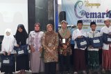 Asisten Perekonomian dan Pembangunan Kota Kediri Enny Endarjati saat memberikan cenderamata kepada para santri di Pondok Pesantren Al-Ishlah Kota Kediri, Jawa Timur, Selasa (11/2/2020). Kegiatan itu bagian dari kampanye gemar makan ikan. Antara Jatim/Asmaul Chusna/zk.