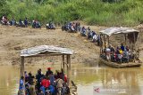 Sejumlah pengendara motor menggunakan jasa perahu eret saat menyeberangi Sungai Citarum di Rengasdengklok, Karawang, Jawa Barat, Rabu (12/2/2020). Jasa penyeberangan perahu tersebut digunakan warga setempat untuk mempersingkat jarak tempuh antara Kabupaten Karawang dan Kabupaten Bekasi dengan ongkos untuk motor Rp2.000 dan mobil Rp10.000 per sekali menyeberang. ANTARA JABAR/M Ibnu Chazar/agr