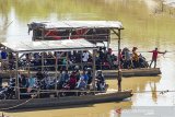 Sejumlah pengendara motor menggunakan jasa perahu eret saat menyeberangi Sungai Citarum di Rengasdengklok, Karawang, Jawa Barat, Rabu (12/2/2020). Jasa penyeberangan perahu tersebut digunakan warga setempat untuk mempersingkat jarak tempuh antara Kabupaten Karawang dan Kabupaten Bekasi dengan ongkos untuk motor Rp2.000 dan mobil Rp10.000 per sekali menyeberang. ANTARA JABAR/M Ibnu Chazar/agr