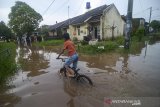 Seorang anak bermain sepeda saat banjir melanda Komplek Bumi Orange, Cileunyi, Kabupaten Bandung, Jawa Barat, Kamis (13/2/2020). Banjir akibat luapan Sungai Ciguruwik setinggi 50 hingga 60 sentimeter tersebut disebabkan intensitas hujan yang tinggi di Kawasan Bandung Timur pada Kamis (13/2) sejak siang hingga sore hari. ANTARA JABAR/Raisan Al Farisi/agr