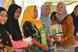 Regional Manager PNM Mekaar Cabang Surabaya, Istiqomah (kanan) memberikan bingkisan kepada nasabah saat temu nasabah program Membina Ekonomi Keluarga Sejahtera (Mekaar) di kantor Kecamatan Balongpanggang, Kabupaten Gresik, Jawa Timur, Jumat (14/2/2020). Kegiatan yang diikuti ratusan nasabah tersebut digelar sebagai upaya meningkatkan semangat para nasabah PNM Mekaar untuk mengembangkan usahanya. Antara Jatim/Syaiful Arif/zk