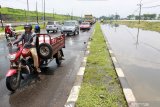 Kendaraan melaju di samping Jalan Raya Porong yang terendam banjir di Porong, Sidoarjo, Jawa Timur, Sabtu (15/2/2020). Banjir dengan ketinggian 20 cm hingga 30 cm di jalan sepanjang 400 meter dari arah Malang ke Surabaya tersebut menyebabkan terganggunya aktivitas transportasi. Antara Jatim/Umarul Faruq/zk