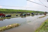 Kendaraan melaju di samping Jalan Raya Porong yang terendam banjir di Porong, Sidoarjo, Jawa Timur, Sabtu (15/2/2020). Jalan raya porong banjir