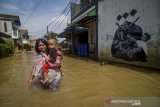 Seorang warga membawa balita menerjang banjir di Bojongasih, Dayeuhkolot, Kabupaten Bandung, Jawa Barat, Senin (17/2/2020). Banjir luapan Sungai Citarum setinggi 50 hingga 150 sentimeter kembali merendam ratusan tempat tinggal sejak Sabtu (15/2) yang membuat 1.413 kepala keluarga terdampak. ANTARA JABAR/Raisan Al Farisi/agr