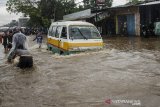 Kendaraan Angkutan Umum melintasi genangan air di kawasan Cikadut, Bandung, Jawa Barat, Minggu (16/2/2020). Genangan air setinggi 40-60 cm tersebut terjadi saat intensitas curah hujan yang tinggi akibat drainase buruk yang juga menyebabkan terjadinya kemacetan lalu lintas. ANTARA JABAR/Novrian Arbi/agr