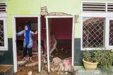 Seorang guru membersihkan puing di salah satu ruang sekolah di SDN 2 Gunung Bentang, Kecamatan Padalarang, Kabupaten Bandung Barat, Jawa Barat, Senin (17/2/2020). Dua ruangan di sekolah tersebut hancur akibat di terjang longsor pada hari Minggu 16 Februari 2020. ANTARA JABAR/M Agung Rajasa/agr