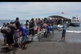 Warga dan wisatawan antre naik ke kapal cepat yang akan menuju pulau Nusa Penida menjelang Hari Raya Galungan di Pelabuhan Tribuana, Klungkung, Bali, Selasa (18/2/2020). Warga yang umumnya berasal dari pulau Nusa Penida dan Nusa Lembongan ramai mudik ke kampung halamannya untuk merayakan Hari Raya Galungan pada Rabu (19/2/2020). ANTARA FOTO/Nyoman Hendra Wibowo/nym