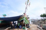 Nelayan memperbaiki kapan di Pelabuhan Muncar Banyuwangi, Jawa Timur, Kamis (20/2/2020). Untuk mengisi libur melaut karena musim angin baratan yang berdampak pada sepinya hasil tangkapan, dimanfaatkan nelayan setempat untuk memperbaiki kapal dan jaring yang rusak. Antara Jatim/Budi Candra Setya/zk