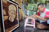 Seniman menyelesaikan lukisan pelepah pohon pisang di salah satu galeri di Pakunden, Kota Blitar, Jawa Timur, Jumat (21/2/2020). Lukisan berbahan limbah pelepah pohon pisang  kering yang dijual dengan harga antara Rp50.000 hingga Rp1,5 juta tersebut dipasarkan hingga ke beberapa kota besar seperti Surabaya, Malang, Bandung, dan Jakarta. Antara Jatim/Irfan Anshori/zk.