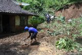 Relawan Tagana membersihkan material tanah longsor di Kelurahan Bintoro, Patrang, Jember, Jawa Timur, Sabtu (22/2/2020). Badan Penanggulangan Bencana Daerah (BPBD) Jember mencatat bencana alam berupa tanah longsor, banjir, dan pohon tumbang terjadi di 16 titik yang tersebar di delapan kecamatan di Jember, akibat  hujan deras dan angin kencang yang melanda Jember, Jumat (21/2/2020) sore. Antara Jatim/Seno/zk