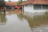 Petugas melintasi banjir yang merendam kantor BPBD Kabupaten Indramayu, Jawa Barat, Senin (24/2/2020). Banjir tersebut akibat tingginya intensitas hujan sejak Minggu (23/2) malam, dan merendam beberapa pemukiman warga. ANTARA JABAR/Dedhez Anggara/agr