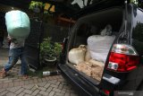 Pekerja mengangkut barang bukti saat penggerebekan rumah produksi jamu kuat ilegal di Babatan Pilang, Surabaya, Jawa Timur, Senin (24/2/2020). Direktorat Reserse Narkoba (Ditresnarkoba) Polda Jawa Timur menangkap tiga orang dalam penggerebekan itu dan mengamankan sejumlah barang bukti beberapa diantaranya alat produksi, jamu kuat siap edar sekitar 50 karton serta bahan baku jamu seberat sekitar 5 kilogram. Antara Jatim/Didik/Zk