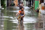 Seorang anak menerobos banjir yang merendam kawasan Sidokare, Sidoarjo, Jawa Timur, Selasa (25/2/2020). Sejumlah wilayah di Kabupaten Sidoarjo, Jawa Timur terendam banjir dengan ketinggian yang bervariasi menyusul tingginya intensitas hujan yang terjadi di wilayah setempat sejak Senin (24/2). Antara Jatim/Umarul Faruq/zk