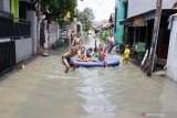 Sejumlah anak bermain air yang terendam kawasan Sidokare, Sidoarjo, Jawa Timur, Selasa (25/2/2020). Sejumlah wilayah di Kabupaten Sidoarjo, Jawa Timur terendam banjir dengan ketinggian yang bervariasi menyusul tingginya intensitas hujan yang terjadi di wilayah setempat sejak Senin (24/2). Antara Jatim/Umarul Faruq/zk