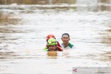 Petugas Basarnas mengevakuasi warga terdampak banjir di Desa Purwasari, Karawang, Jawa Barat, Selasa (25/2/2020). Banjir yang disebabkan meluapnnya air sungai Cikaranggelam di wilayah itu merendam ratusan rumah dengan ketinggian air mencapai 1,5 meter hingga 2 meter mengakibatkan 920 jiwa terpaksa mengungsi ke dataran yang lebih tinggi. ANTARA JABAR/M Ibnu Chazar/agr