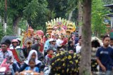 Pengantin diarak keliling kampung diiringi kesenian lokal di Sobo, Banyuwangi, Jawa Timur, Rabu (26/2/2020). Mengarak pengantin dengan diiringi kesenian lokal seperti barong osing, pitik-pitikan dan musik tradisional itu, merupakan tradisi turun-temurun yang masih dilestarikan masyarakat Banyuwangi. Antara Jatim/Budi Candra Setya/zk