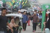 Warga melintas di jalan Sekumpul, Martapura, Kabupaten Banjar, Kalimantan Selatan, Jumat (28/2/2020). Jelang peringatan Haul ke-15 KH Muhammad Zaini Abdul Ghani (Abah Guru Sekumpul), kawasan Sekumpul Martapura hingga sekitaran Makam Abah Guru Sekumpul sudah dipadati jamaah dari luar Negeri maupun dalam Negeri untuk mengikuti rangkaian kegiatan haul. Foto Antaranews Kalsel/Bayu Pratama S.