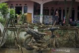 Warga membersihkan rumah dari lumpur pascabanjir di Kawasan Sayang, Jatinangor, Sumedang, Jawa Barat, Sabtu (29/2/2020). Sedikitnya 2000 jiwa dari 660 kepala keluarga di lima area kawasan Jatinangor tersebut terdampak banjir bandang yang sehingga sejumlah pemukiman rusak berat dan ringan karena meluapnya aliran sungai Cikeruh pada Jumat (28/2/2020) lalu. ANTARA JABAR/Novrian Arbi/agr