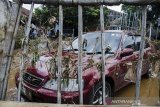 Sebuah kendaraan roda empat mengalami kerusakan akibat banjir di Kawasan Sayang, Jatinangor, Sumedang, Jawa Barat, Sabtu (29/2/2020). Sedikitnya 2000 jiwa dari 660 kepala keluarga di lima area kawasan Jatinangor tersebut terdampak banjir bandang yang sehingga sejumlah pemukiman rusak berat dan ringan karena meluapnya aliran sungai Cikeruh pada Jumat (28/2/2020) lalu. ANTARA JABAR/Novrian Arbi/agr