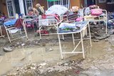 Warga membersihkan barang-barang rumah tangga pascabanjir di Desa Karangligar, Karawang, Jawa Barat, Jumat (28/2/2020). Warga mulai membenahi dan membersihkan rumah pascabanjir luapan Sungai Cibeet yang melanda permukiman warga di wilayah itu yang berangsur surut. ANTARA JABAR/M Ibnu Chazar/agr
