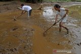 Warga membersihkan lumpur pascabanjir di desa Sayang, Jatinagor, Kabupaten Sumedang, Jawa Barat, Sabtu (29/2/2020). Banjir yang melanda empat desa di Sumedang diakibatkan curah hujan yang tinggi dan meluapnya dua sungai Cikeruh dan sungai Citarik. ANTARA JABAR/Candra Yanuarsyah