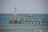 Pengunjung menikmati pemandangan bahari di kafe terapung dengan bangunan menyerupai menara eiffel di Pantai Wisata Desa Bayeun Kecamatan Leupung, Kabupaten Aceh Besar, Aceh, Sabtu (29/2/2020). Pantai wisata Leupung , Aceh Besar terus berkembang dengan inovasi baru dan kreatif yang menyediakan fasilitas kafe terapung, menara eiffel, kuliner ikan segar yang menjadi salah satu destinasi wisata bahari. Antara Aceh/Ampelsa.