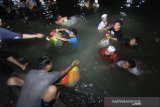 Sejumlah relawan haul KH Muhammad Zaini Abdul Ghani (Abah Guru Sekumpul) bergotong royong membersihkan beras di Irigasi Martapura, Kalimantan Selatan, Sabtu (29/2/2020).Puluhan ton beras disiapkan untuk konsumsi jamaah yang menghadiri Haul Abah Guru Sekumpul ke-15. Foto Antaranews Kalsel/Bayu Pratama S.