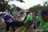 Petugas bersama relawan memindahkan mobil yang parkir di bahu jalan Ahmad Yani, Martapura, Kabupaten Banjar, Kalimantan Selatan, Minggu (1/3/2020). Pada Puncak Haul Abah Guru Sekumpul suasana kota Martapura sudah dipenuhi jamaah yang datang dari luar Negeri maupun dalam Negeri yang datang untuk mengikuti kegiatan haul. Foto Antaranews Kalsel/Bayu Pratama S.