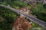 Foto udara pengerjaan proyek perbaikan longsor di Jalan Tol Cipularang KM 118, Padalarang, Kabupaten Bandung Barat, Jawa Barat, Minggu (1/3/2020). Korlantas Polri menyiapkan rekayasa jalur di lokasi terdampak longsor Tol Cipularang KM 118 jika terjadi cuaca ekstrem dengan mengalihkan arus kendaraan arah Jakarta melalui pintu keluar Padalarang Timur. ANTARA JABAR/Raisan Al Farisi/agr