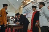 Ketua KPU Pandeglang Ahmad Sujai menandatangani berkas acara pelantikan disaksikan rohaniawan