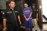 Polisi membawa tersangka kasus penanaman ganja di Perum Wisma Lidah Kulon, Surabaya, Jawa Timur, Rabu (4/3/2020). Direktorat Reserse Narkoba Polda Jawa Timur menangkap tersangka berinisial V atas kasus dugaan menanam tanaman ganja dan mengamankan barang bukti 27 tanaman ganja yang ditanam secara hidroponik. Antara Jatim/Didik/Zk