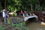 Anggota TNI-POLRI meninjau jembatan yang ambrol diterjang banjir di Desa Alas Buluh, Wongsorejo, Banyuwangi, Jawa Timur, Kamis (5/3/2020). Hujan deras yang mengguyur daerah hulu di daerah itu, mengakibatkan jembatan putus serta puluhan hektar lahan pertanian cabai rusak. Antara Jatim/Budi Candra Setya/zk.