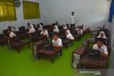 Siswa Madrasah Aliyah (MA) Syarif Hidayatulloh mengikuti Ujian Akhir Madrasah Berstandar Nasional Berbasis Komputer (UAMBN-BK) dengan lesehan di Desa Medali, Kecamatan Puri, Kabupaten Mojokerto, Jawa Timur, Selasa (10/3/2020). Kebakaran yang terjadi sekitar pukul 02.30 WIB tersebut mengakibatkan empat ruangan di sekolah dan puluhan komputer yang digunakan untuk Ujian Akhir Madrasah Berstandar Nasional Berbasis Komputer (UAMBN-BK) rusak. Antara Jatim/Syaiful Arif/zk.