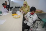 Seorang instruktur mengajarkan siswa disabilitas untuk membuat lemper saat pelatihan olah pangan bagi disabilitas di kompleks Dinas Sosial Provinsi Jawa Barat, Cimahi, Jawa Barat, Selasa (10/3/2020). Sebanyak 16 siswa disabilitas menerima materi olah pangan tradisional yang ditujukan agar disabilitas dapat berwirausaha dan masuk dalam dunia bursa kerja. ANTARA JABAR/Raisan Al Farisi/agr