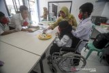 Seorang instruktur mengajarkan siswa disabilitas untuk membuat lemper saat pelatihan olah pangan bagi disabilitas di kompleks Dinas Sosial Provinsi Jawa Barat, Cimahi, Jawa Barat, Selasa (10/3/2020). Sebanyak 16 siswa disabilitas menerima materi olah pangan tradisional yang ditujukan agar disabilitas dapat berwirausaha dan masuk dalam dunia bursa kerja. ANTARA JABAR/Raisan Al Farisi/agr