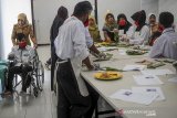 Instruktur mengajarkan siswa disabilitas untuk membuat lemper saat pelatihan olah pangan bagi disabilitas di kompleks Dinas Sosial Provinsi Jawa Barat, Cimahi, Jawa Barat, Selasa (10/3/2020). Sebanyak 16 siswa disabilitas menerima materi olah pangan tradisional yang ditujukan agar disabilitas dapat berwirausaha dan masuk dalam dunia bursa kerja. ANTARA JABAR/Raisan Al Farisi/agr