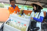 Penjual jamu keliling Kinanti (kanan), melayani pembeli jamu tradisional di Kelurahan Dawuhan, Situbondo, Jawa Timur, Selasa (10/3/2020). Sejak merebaknya wabah virus Corona (COVID-19) penjualan jamu tradisional tersebut permintaanya meningkat dari sebelumnya, yaitu dari 20 botol isi 1,5 liter menjadi 35 botol per hari dengan harga jual mulai Rp2500 per gelas, yang berisi ramuan temulawak, jahe, serai, kunyit. Antara Jatim/Seno/zk