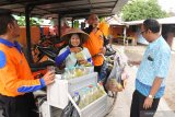 Penjual jamu keliling Kinanti (tengah), melayani pembeli jamu tradisional di Kelurahan Dawuhan, Situbondo, Jawa Timur, Selasa (10/3/2020). Sejak merebaknya wabah virus Corona (COVID-19) penjualan jamu tradisional tersebut permintaanya meningkat dari sebelumnya, yaitu dari 20 botol isi 1,5 liter menjadi 35 botol per hari dengan harga jual mulai Rp2500 per gelas, yang berisi ramuan temulawak, jahe, serai, kunyit. Antara Jatim/Seno/zk