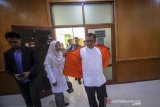 Terdakwa kasus suap proyek pembangunan Indramayu yang juga Bupati Indramayu nonaktif, Supendi membuka rompi tahanan KPK sebelum menjalani sidang perdana dengan agenda pembacaan dakwaan di Pengadilan Tipikor, Bandung, Jawa Barat, Senin (9/3/2020). Dalam sidang tersebut, Supendi di dakwa menerima uang hingga Rp 3,9 miliar lebih dari sejumlah pengusaha untuk mengatur proyek pembangunan di Kabupaten Indramayu. ANTARA JABAR/Raisan Al Farisi/agr