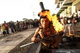 Muhammad Arsyad (80) melakukan atraksi api di kawasan Menara Pandang Banjarmasin, Kalimantan Selatan, Rabu (11/3/2020). Muhammad Arsyad atau biasa dipanggil dengan Kai Api yang merupakan mantan atlet lari tersebut telah menjalani atraksi api selama 16 tahun dengan memanfaatkan kekebalan tubuhnya terhadap api. Foto Antaranews Kalsel/Bayu Pratama S.