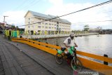 Warga melintas di  jalan Teluk Kelayan Banjarmasin, Kalimantan Selatan, Kamis (12/3/2020). Rusunawa yang selesai dibangun pada 2019 tersebut dengan kapasitas 50 kepala keluarga hingga kini sepi peminat berdasarkan data Dinas Perumahan dan Kawasan Kumuh Kota Banjarmasin Rusunawa tersebut hanya dihuni sepuluh kepala keluarga saja. Foto Antaranews Kalsel/Bayu Pratama S.