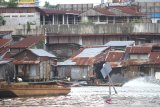 Sejumlah warga beraktivitas di bantaran sungai Martapura di kawasan pasar lima Banjarmasin, Kalimantan Selatan, Kamis (12/3/2020). Berdasarkan data Dinas Perumahan dan Kawasan Permukiman Kota Banjarmasin kawasan kumuh di kota Banjarmasin pada tahun 2019 tersisa 117 hektar dari 549 hektar sebanyak 40 persen di bantaran sungai, pada 2020 Pemko Banjarmasin lebih fokus ke pencegahan dengan anggaran yang disediakan sebesar Rp10 miliar yang diambil dari APBD serta bantuan dari pusat. Foto Antaranews Kalsel/Bayu Pratama S.