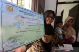 Petugas kesehatan Puskesmas Ulee Kareng memperlihatkan sertifikat imunisasi untuk diserahkan kepada orang tua dan bayi balita di Desa Pango Raya, Banda Aceh, Aceh, Kamis (120320). Dinkes Kota Banda Aceh menyerahkan penghargaan berupa sertifikat kepada orang tua yang telah memberikan imunisasi lengkap kepada bayi balitanya. Antara Aceh/Irwansyah Putra.