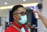 Nasabah diperiksa suhu tubuhnya oleh petugas di Bank Mandiri Banyuwangi, Jawa Timur, Jumat (13/3/2020). Untuk mengantisipasi dan mencegah penyebaran COVID-19, Manajemen Bank Mandiri di Banyuwangi melakukan pemeriksaan suhu tubuh dan menyediakan cairan 'hand sanitizer' bagi nasabahnya. Antara Jatim/Budi Candra Setya/zk